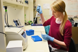Charlotte Hacker at a lab bench using a pipette. Photo provided by Charlotte Hacker