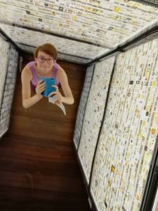 Sarah Alewijnse looking up toward the ceiling in a museum exhibit. The picture is a selfie and taken from the reflection of a mirror on the ceiling. Photo provided by Sarah Alewijnse