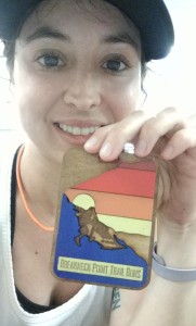 Caitlyn Cardetti holding a Breakneck Point Trail Runs badge. Photo provided by Caitlyn Cardetti